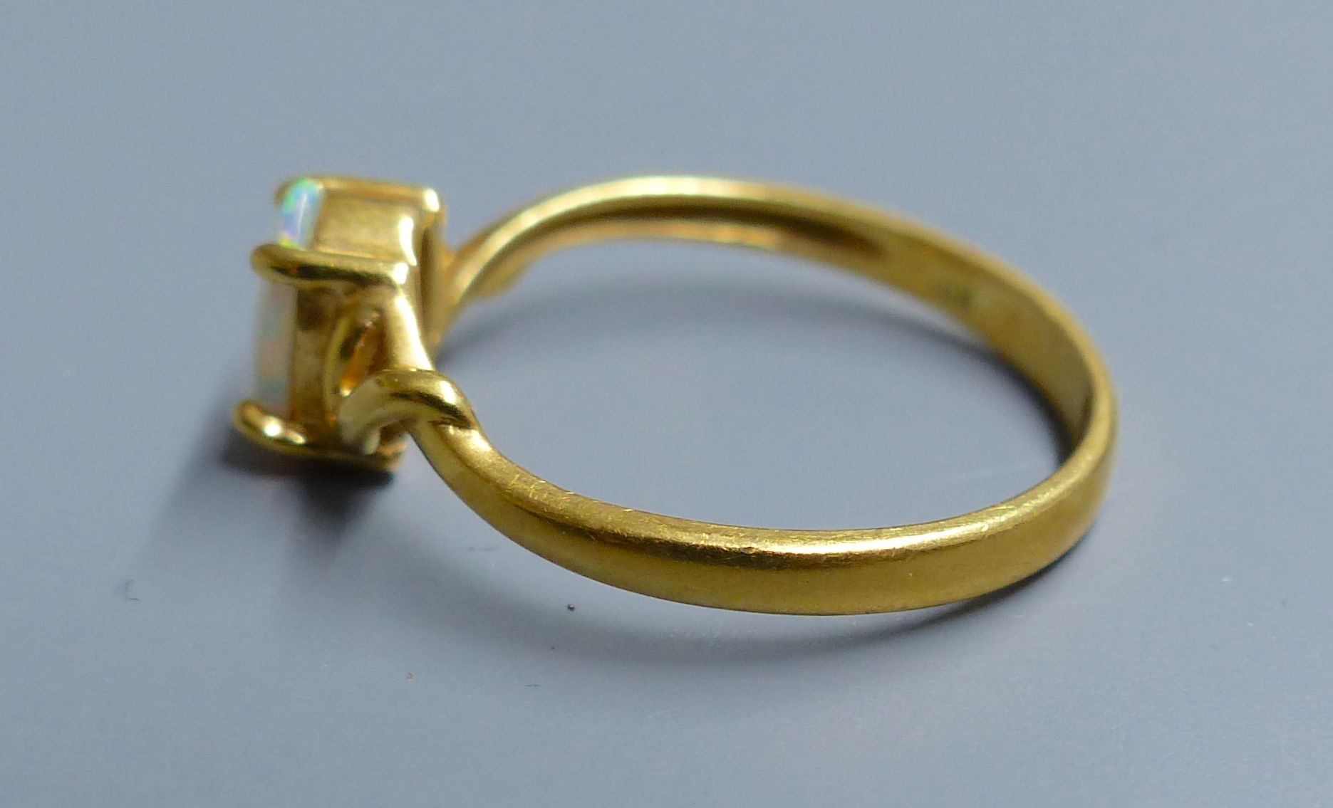 An 18k and single stone white opal ring, size O, gross 2.5 grams.